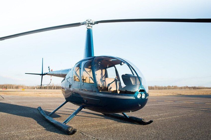 A blue helicopter on a tarmac with a clear sky in the background. 2