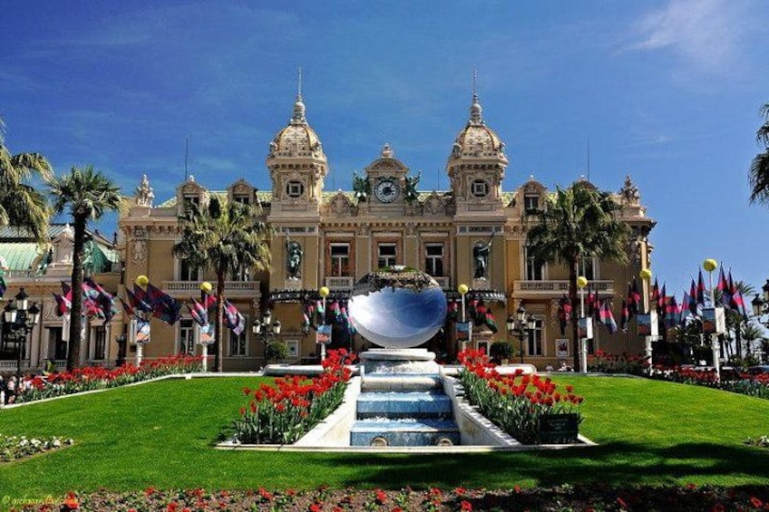A grand building with a fountain, surrounded by well-maintained gardens and palm trees. 2