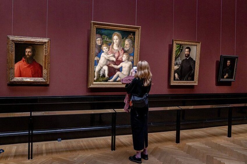 Interior de un museo con una persona fotografiando un cuadro. 4