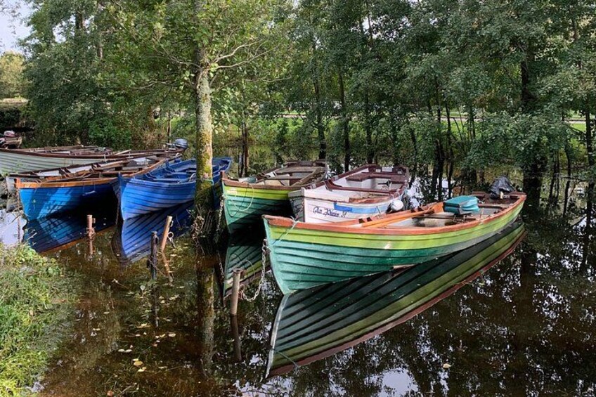 Une rangée de bateaux aux couleurs vives était amarrée dans un cours d’eau paisible, entouré d’arbres. 2