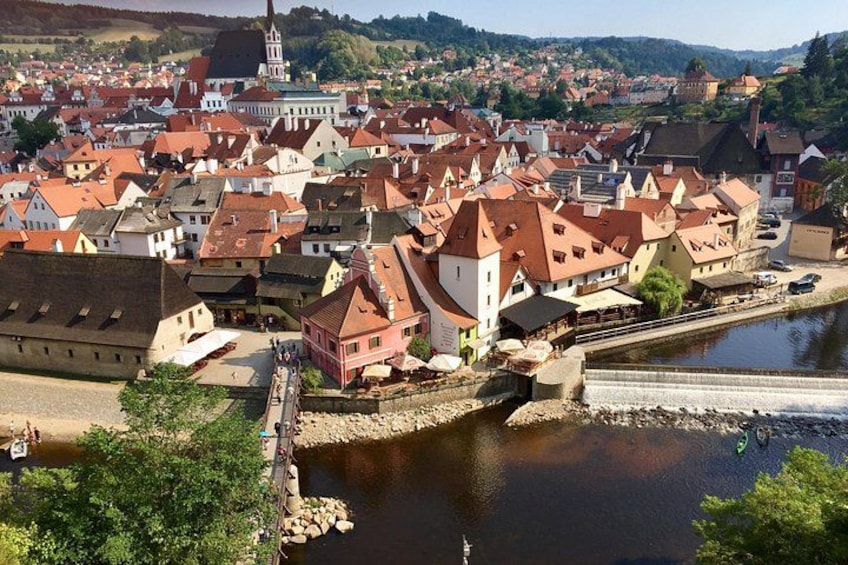 Eine Stadt mit roten Dächern, einem Fluss und einer Brücke. 5