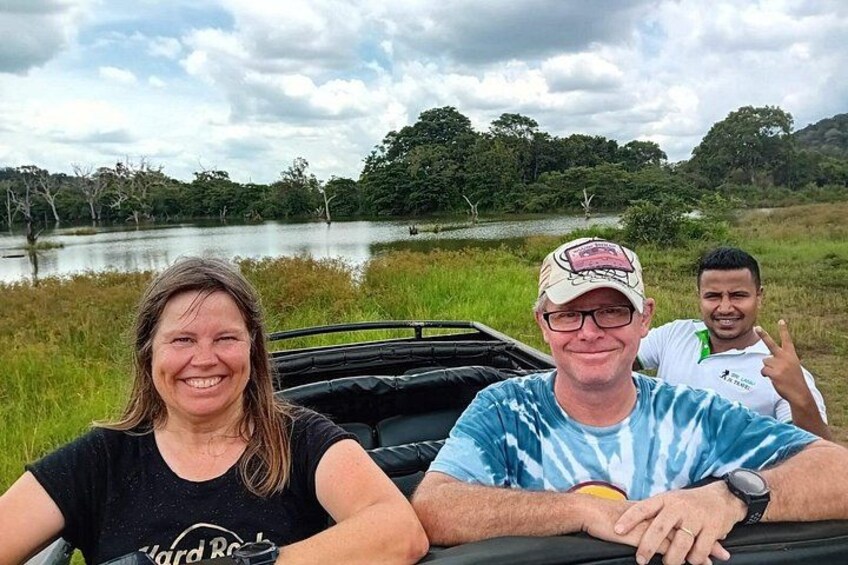 Tres personas sentadas en un vehículo cerca del agua, con árboles al fondo. 4