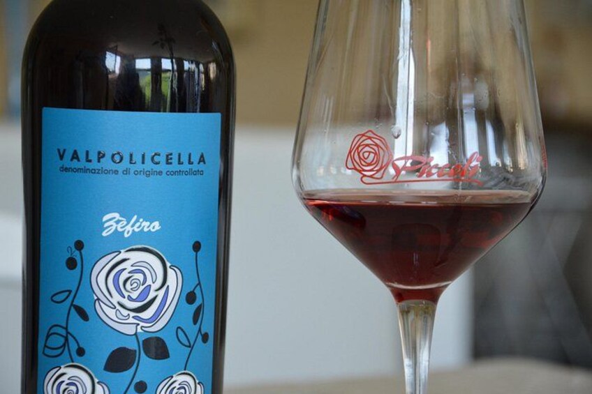 En flaske Valpolicella vin og et vinglas med rødvin. 3