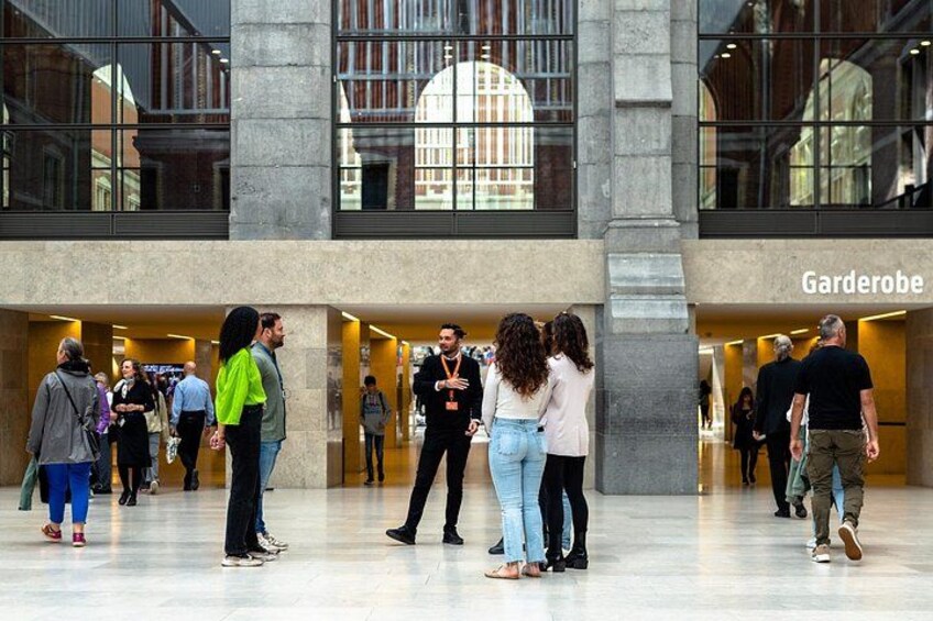 A public indoor space with a modern architectural design, featuring a large open area with a polished floor and a prominent entrance labeled 'Garderobe.' 2