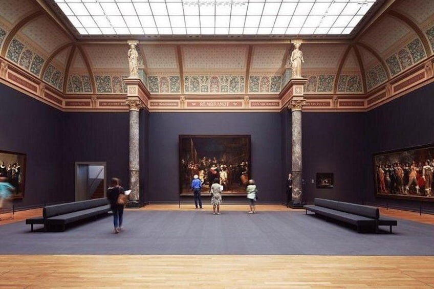 Una galleria d'arte con soffitto alto, dipinti di grandi dimensioni e architettura classica. 2
