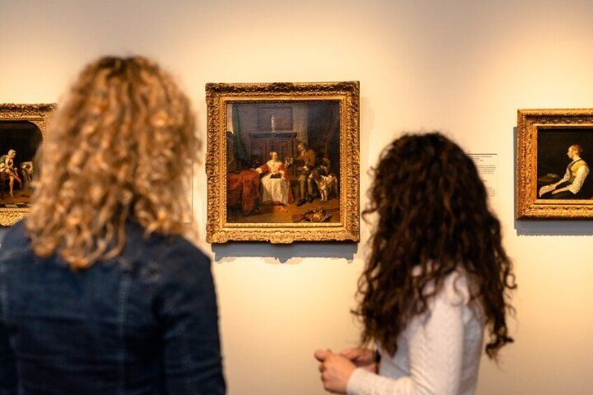 Two people observing paintings in a gallery. 2