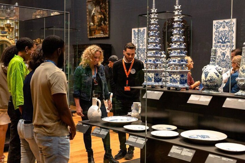 A museum exhibit with ceramic dishes and a person in a lanyard. 3