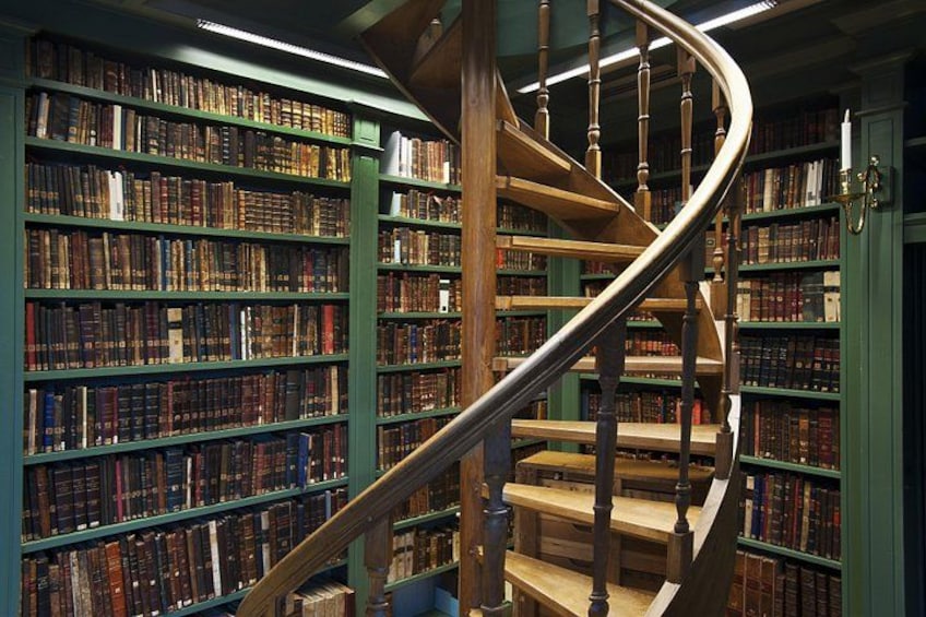 A spiral staircase in a library surrounded by bookshelves. 4