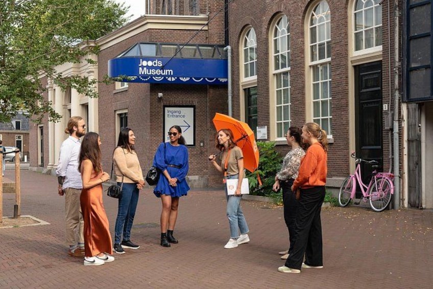 Eine Gruppe von Personen steht vor dem Leeds Museum, wobei ein Schild den Ingang-Eingang kennzeichnet. 3