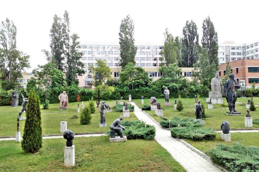 Un cementerio con numerosas estatuas y tumbas, rodeado de árboles y un sendero. 2