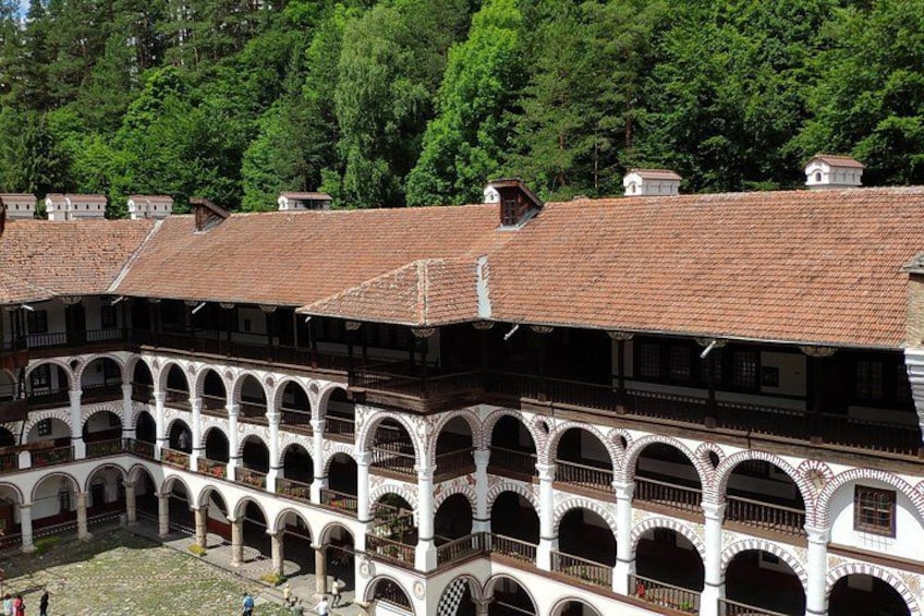 A courtyard with white arches and red-tiled roofs. 1