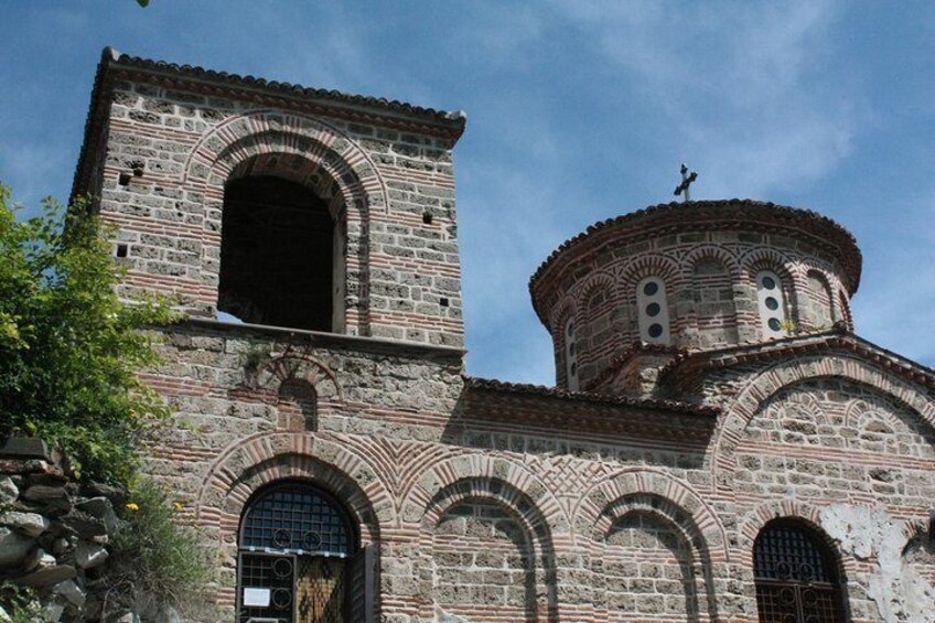 Una iglesia histórica de piedra con ventanas de arco y un campanario. 1