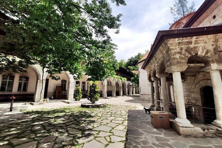 Un patio con senderos de piedra, columnas y arcos. 4