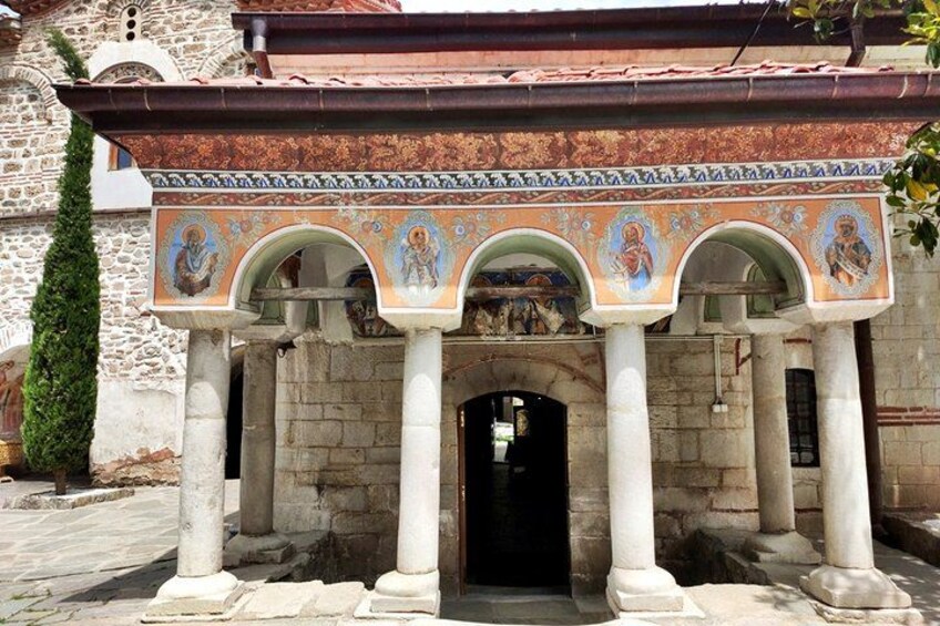 Un edificio histórico con columnas y arcos, que presenta detallados trabajos en mosaico. 3