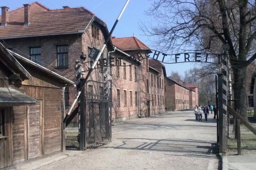 A street with old buildings, a sign reading "FREIHEIT", and people walking. 2