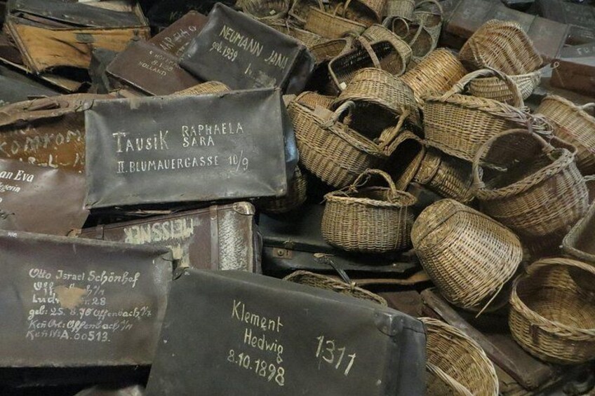 A collection of old, weathered baskets and leather bags with handwritten labels. 2