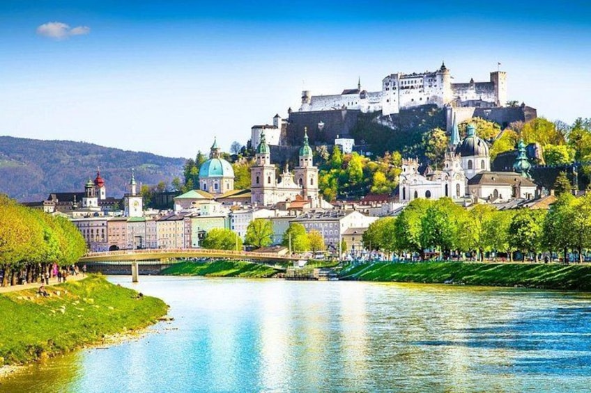 A river with a bridge, a castle on a hill, and a cityscape with buildings. 4