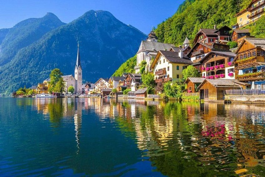 A lakeside village with colorful houses, a church, and mountains in the background. 5