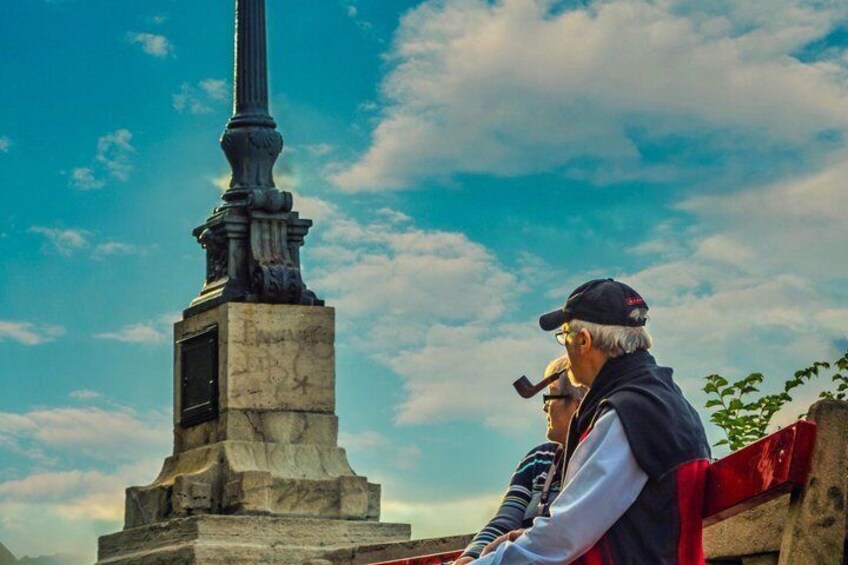 En person med en mikrofon, ett högt monument och en klar himmel. 3
