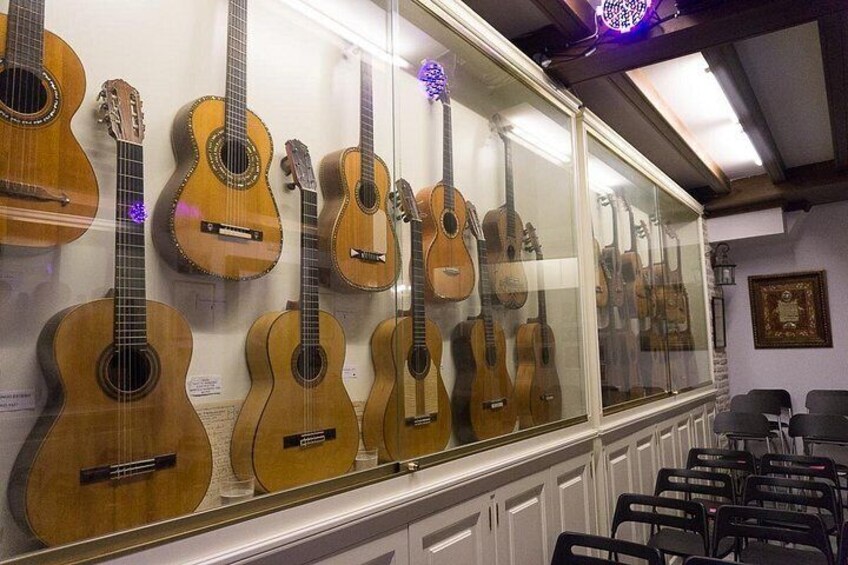 Een vitrine met verschillende akoestische gitaren. 1