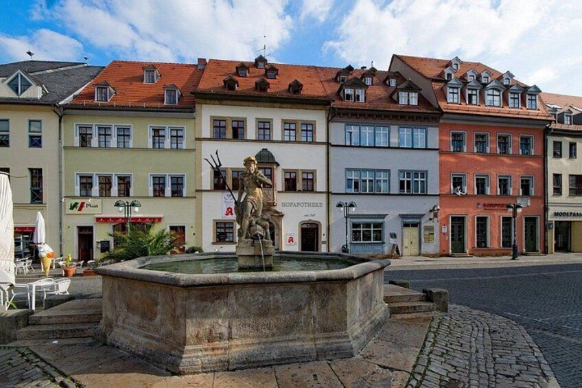 Una fuente histórica con estatuas, rodeada de edificios coloridos de arquitectura tradicional. 5