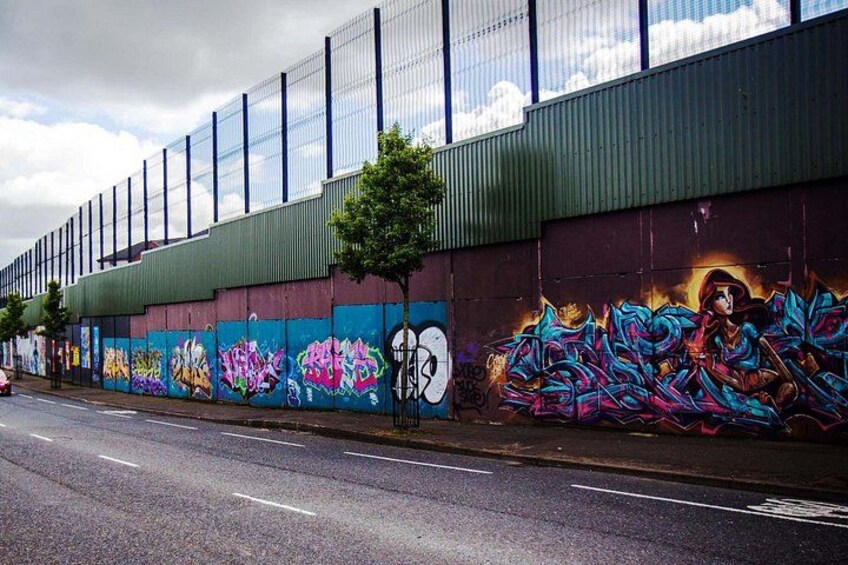 A street with a building featuring colorful graffiti art on its side. 5
