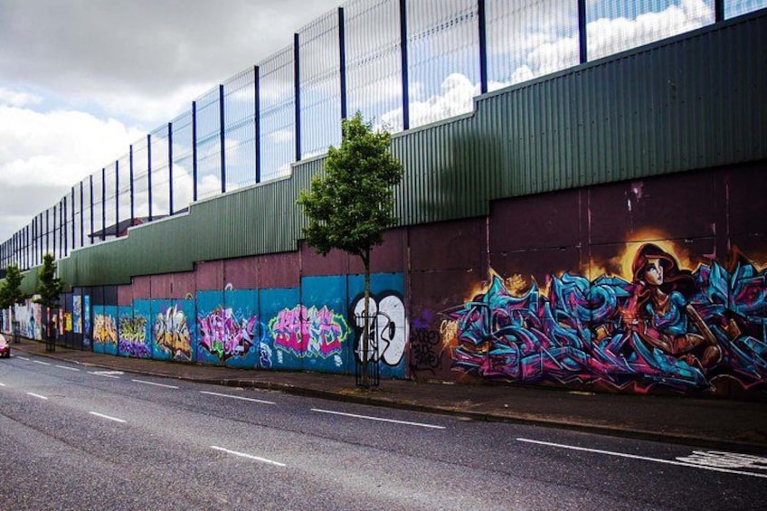 A street with a building featuring colorful graffiti art. 5