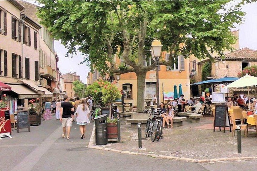Een levendige straat met voetgangers, terrasjes en een fiets. 4