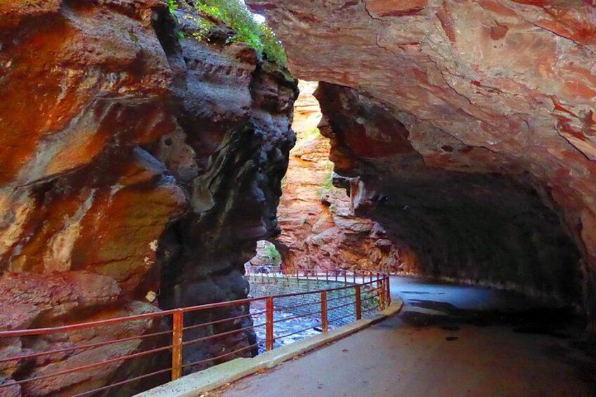 A cave entrance with a metal railing. 1