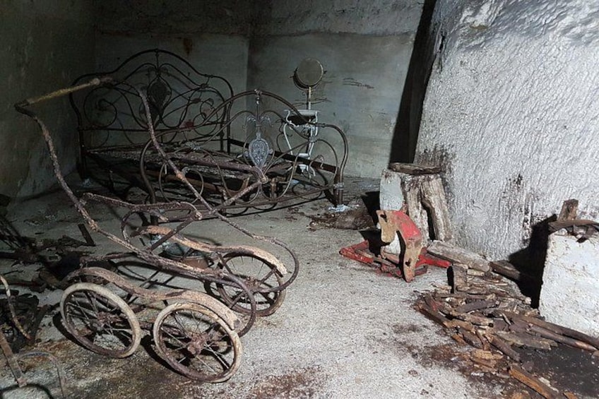 Una habitación desordenada con bicicletas antiguas, una silla rota y escombros dispersos. 3