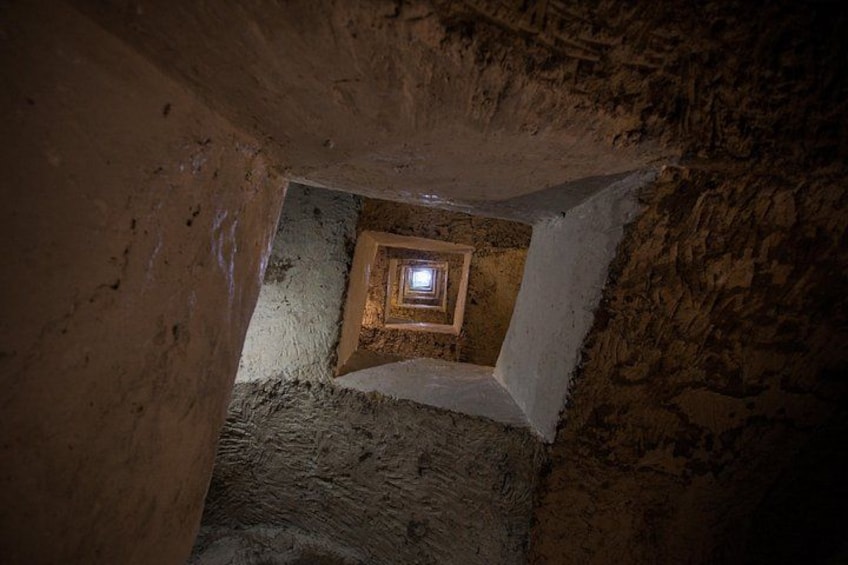 Una escalera de piedra conduce a una habitación pequeña e iluminada al final de una cueva. 5