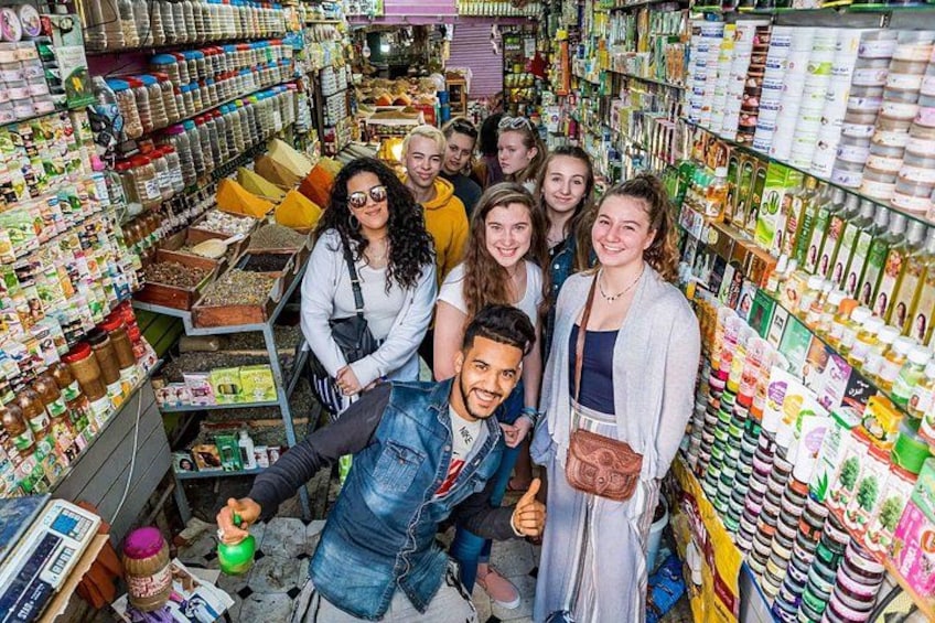 A group of people in a store aisle with shelves stocked with various products. 3
