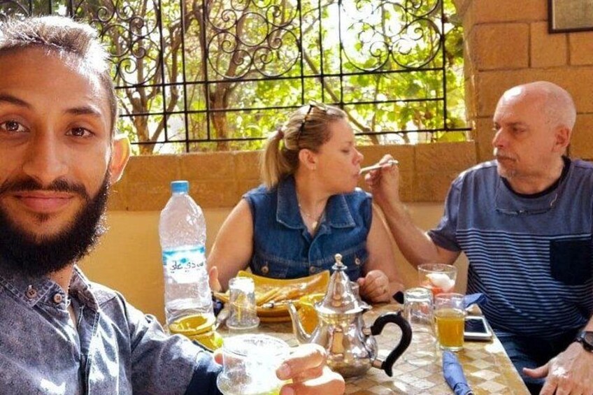 Un grupo de personas sentadas a una mesa con bebidas y una botella de agua. 5