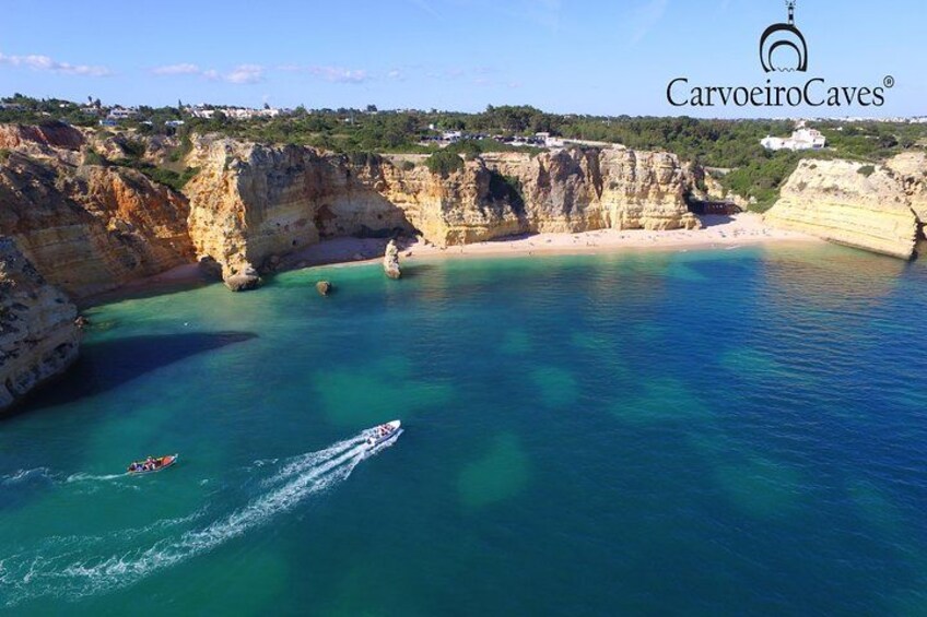 A coastal landscape with cliffs, clear blue water, and a boat. 5