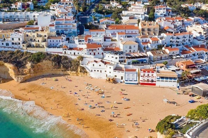 A coastal town with white buildings, a sandy beach, and boats. 3