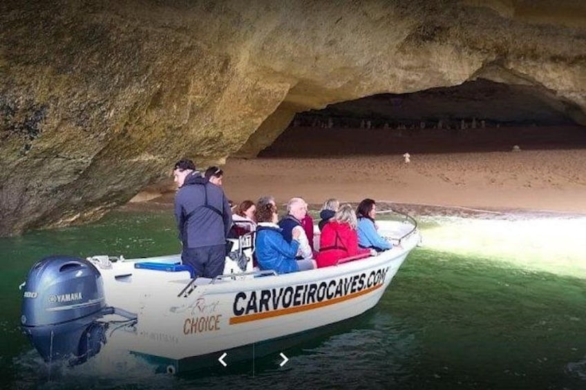 A boat with people on a rocky shore. 4