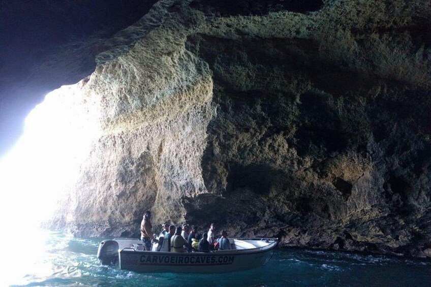 A boat with people on a rocky coastline. 3