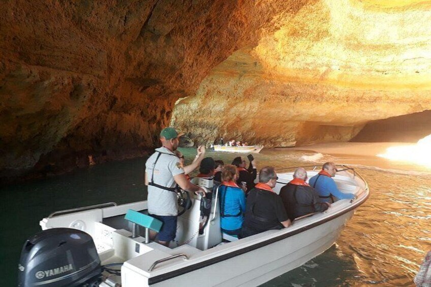 A boat tour inside a cave with people observing the cave walls. 2