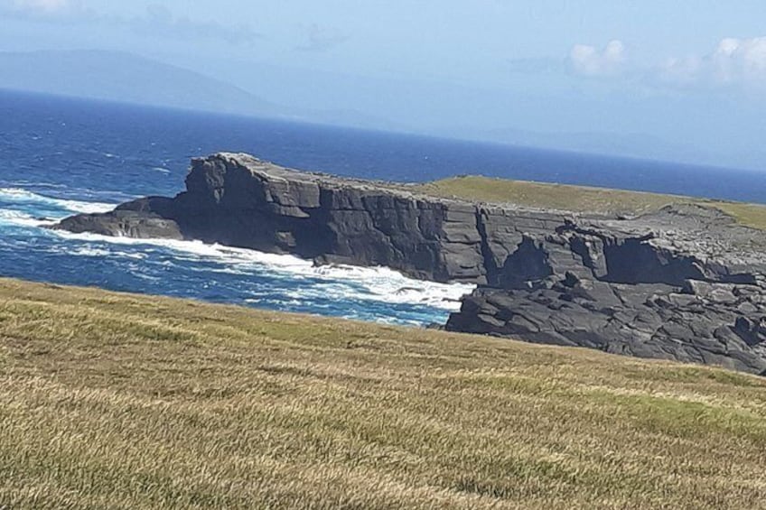A coastal landscape with rocky cliffs and the ocean. 2