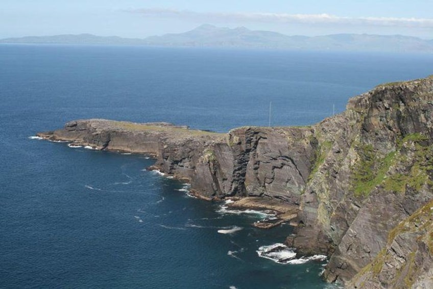 A rugged coastline with steep cliffs and a clear view of the ocean. 3