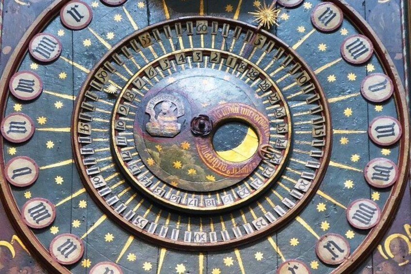 A detailed astronomical clock with zodiac symbols and a central dial. 5