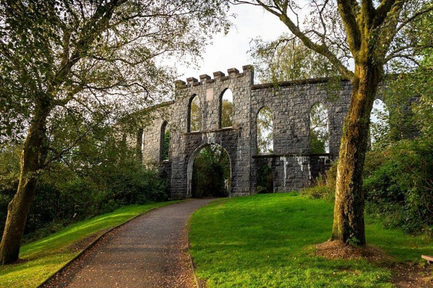 A stone bridge with arches, surrounded by trees and grass. 2