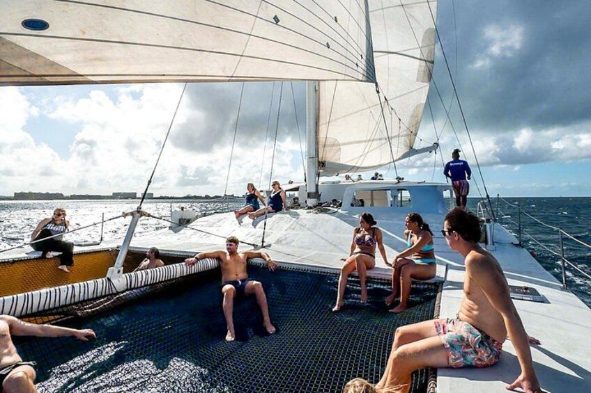 A sailboat with people relaxing on the deck and a pool area. 3