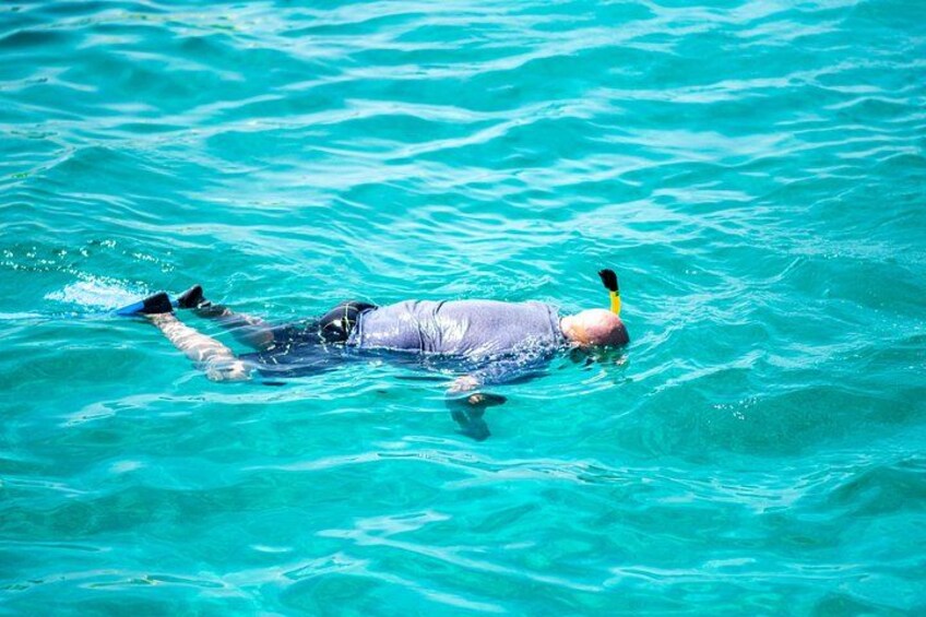 A person snorkeling in clear turquoise water. 2
