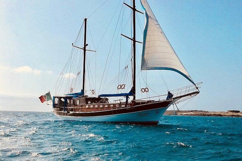 En segelbåt med flera master och segel, som seglar på ett vattendrag. 1