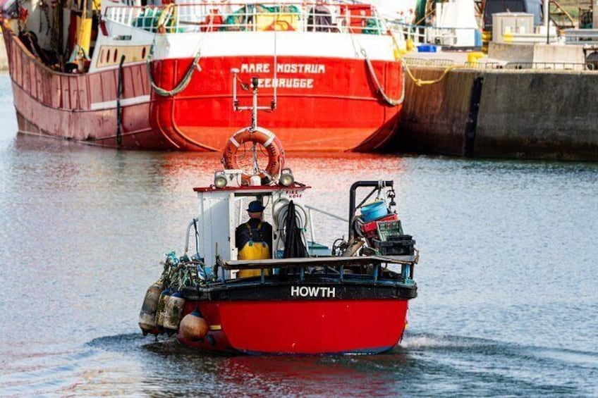 Un bateau rouge nommé « HOWTH », avec une personne à bord, était amarré près d’un plus grand navire rouge appelé « Mare Nostrum ». 3