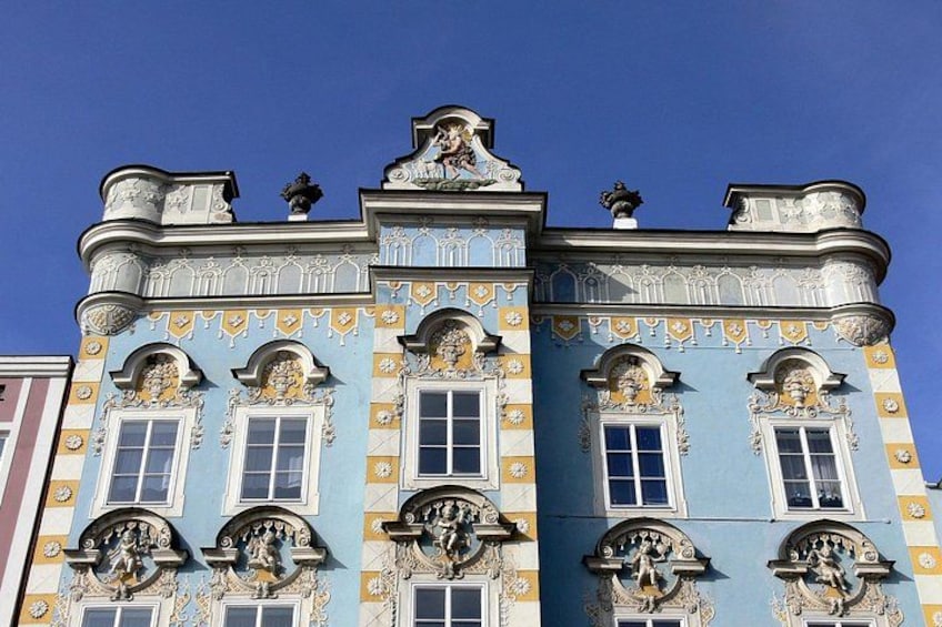 Un edificio con detalles arquitectónicos ornamentados, incluyendo ventanas decorativas y esculturas. 3