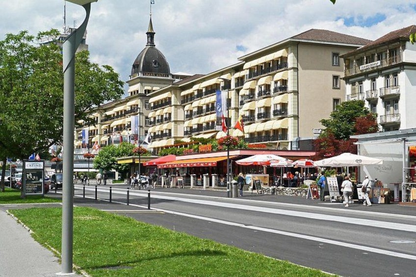 Una strada con edifici, bandiere e tavoli all'aperto. 2
