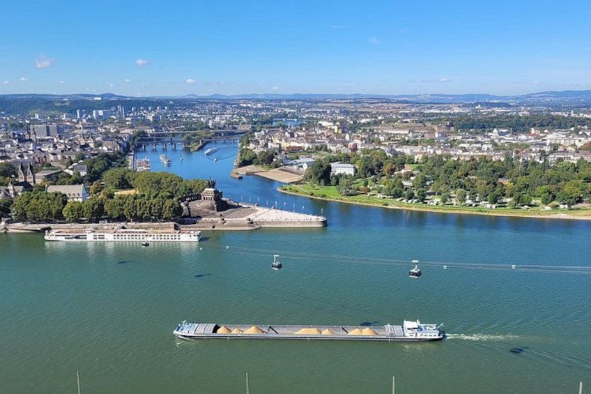 A river with a large ship, a cityscape in the background, and a bridge. 2