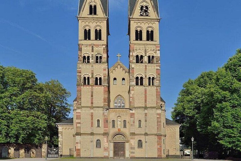A church with two tall towers, a central entrance, and a cross on top. 5